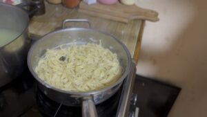 Mešanje taljatela sa puterom, parmezanom i vodom od testenine