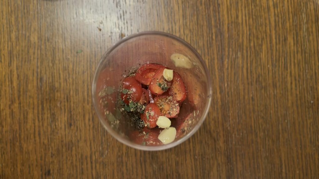 Pomešani sastojci za dresing od paradajza i origana.