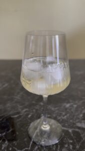 Dodavanje prosecca u čašu sa ledom za Campari Spritz
