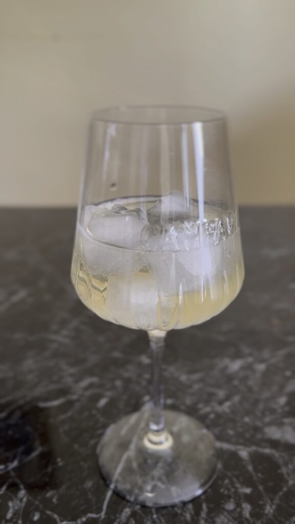 Dodavanje prosecca u čašu sa ledom za Campari Spritz