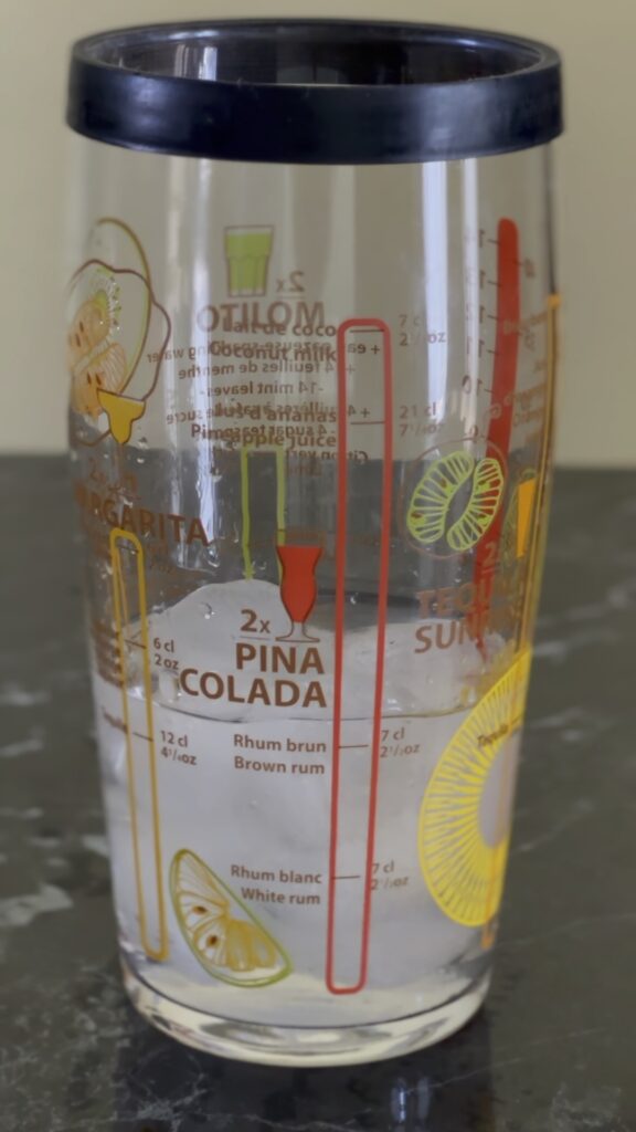 Dodavanje belog ruma u šejker za Piña Coladu