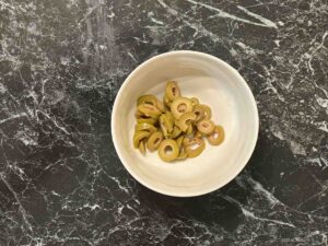 Fregola sa plavim paradajzem - iseckati masline na kolutove