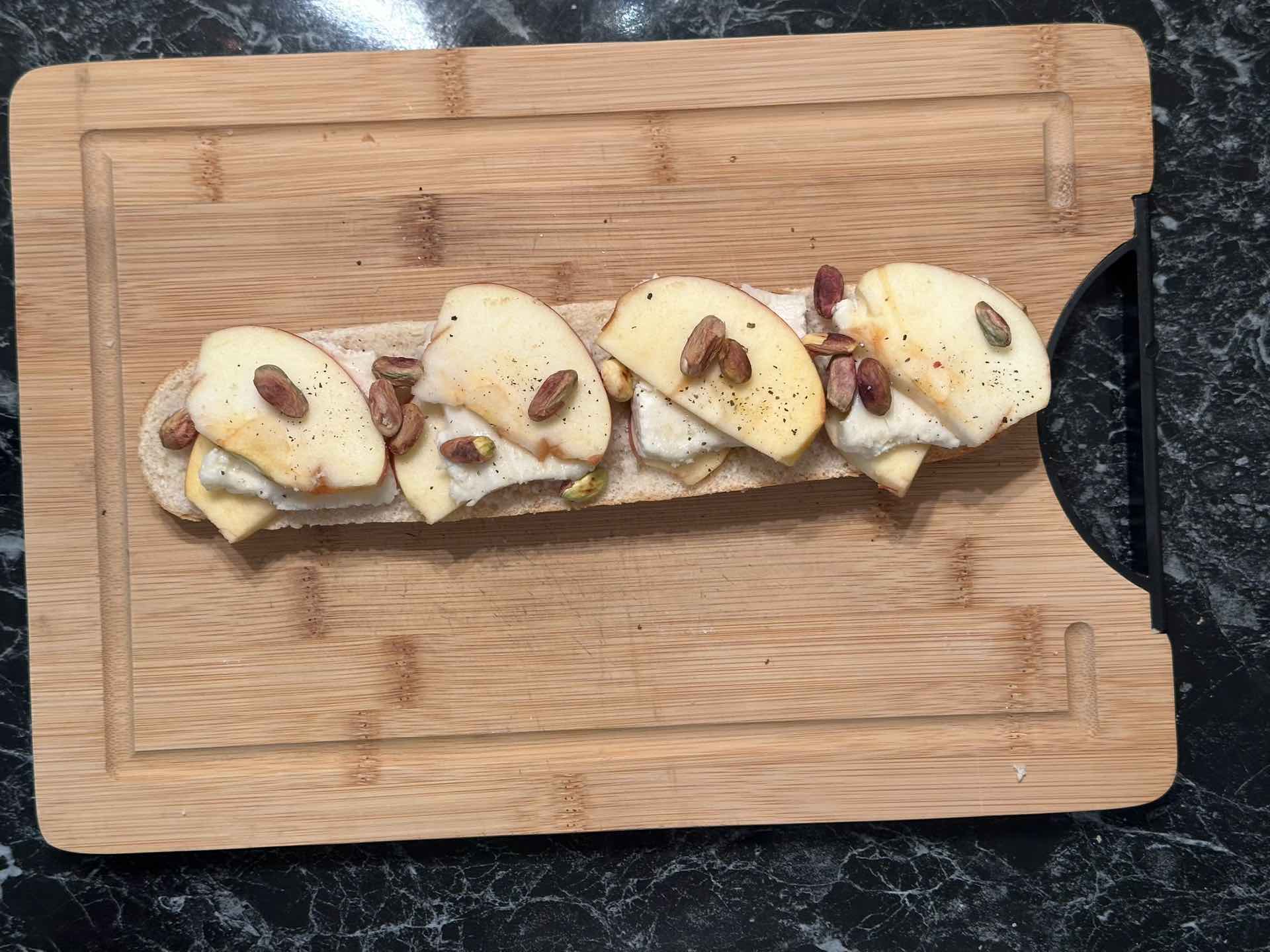 Polovina hleba sa slojem jabuka i sira, dodati pistaće i začiniti.