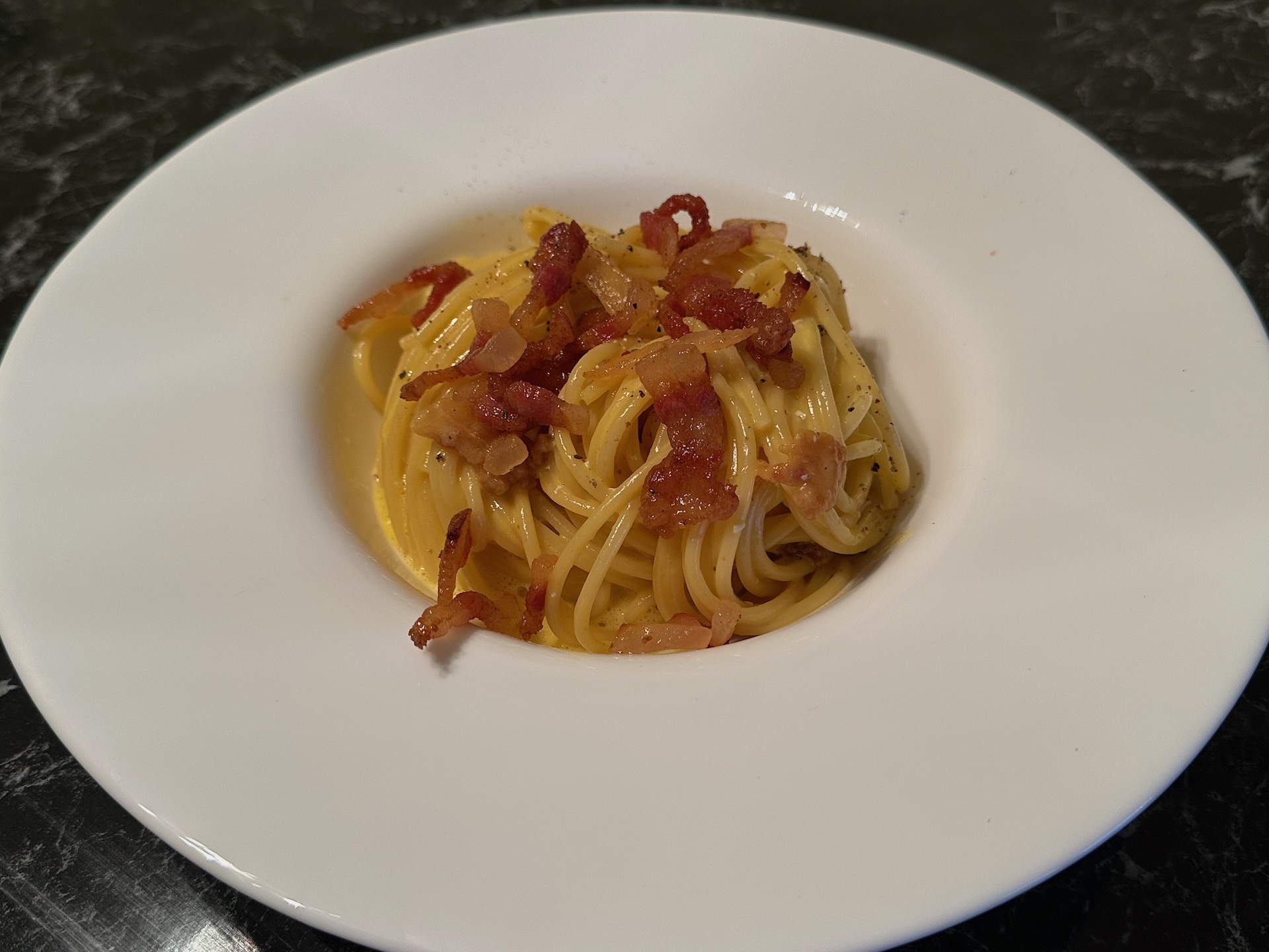 Špagete Karbonara sa guanciale slaninom, Pecorino Romano sirom i sveže mlevenim biberom.