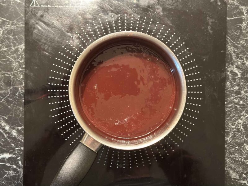 Tamna čokoladna glazura od kakaa i slatke pavlake u šerpici nakon kratkog kuvanja.
