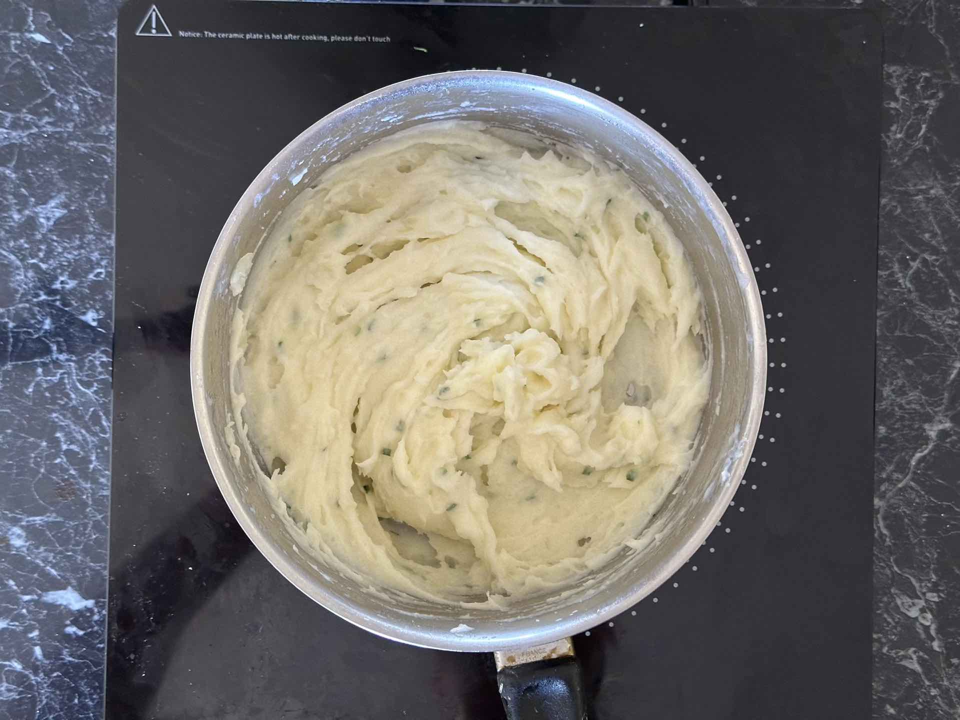 Izgnječen krompir pomešan sa mlekom, maslacem i vlašcem u šerpi