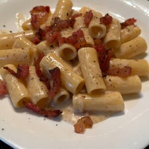 Pasta alla gricia sa rigatoni testeninom, kremastim pekorino sosom i hrskavim guancialeom.