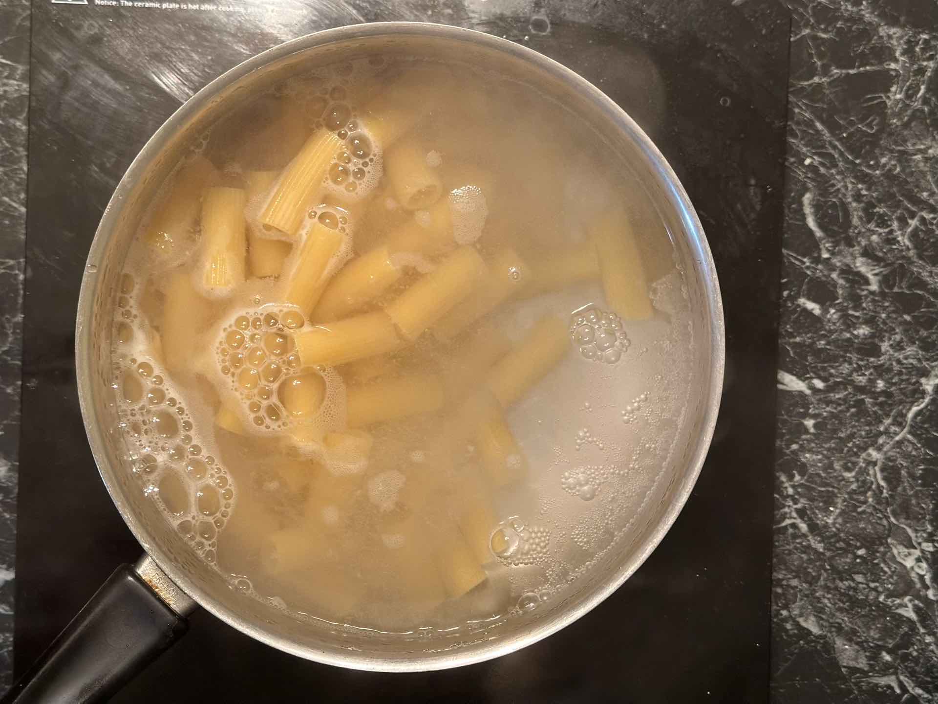 Rigatoni testenina kuva se u loncu sa ključalom vodom.