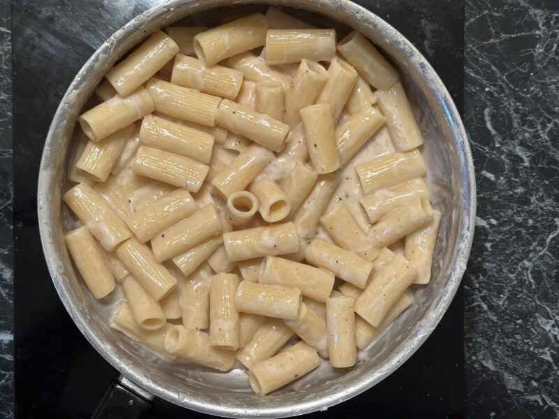 Rigatoni testenina i pekorino krema tokom spajanja u tiganju.